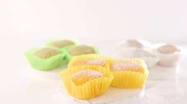 Traditional Japanese dessert mochi. Colorful mochi ice cream on a white table, whole and cut with berry, fruit filling. Sweetness for children on the boys day holiday. 