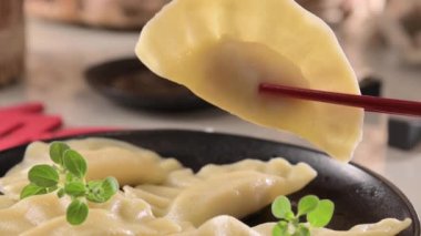 Dim sum. Ev yapımı Çin köfteleri siyah bir tabakta servis edilir. Yemek çubuklarıyla yiyorlar. Doğu mutfağı, geleneksel öğle yemeği için hafif atıştırmalıklar. dikey video