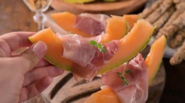Kavunlu İtalyan jambonu. Kavunlara sarılmış geleneksel jambon dilimleri. Lezzetli aperatif. Yemek arkaplanı. Kapatın. Şarap için aperatif.