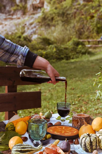 Autumn picnic. Table prepared for lunch in autumn nature, picnic . Harvest, autumn lunch, Wine and glasses. Outdoor meeting