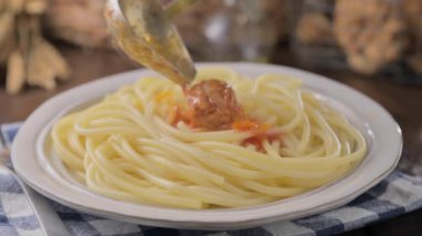 plate of pasta with meatballs on a wooden table. Traditional meatballs with tomato bolognese sauce and herbs. baby food . High quality 4k footage. Hot steam from a dish