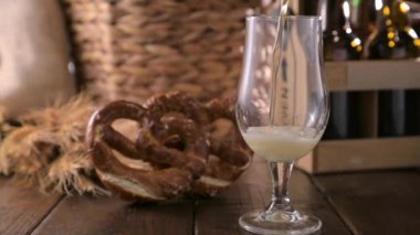 A glass of light craft beer on a wooden table. Beer is poured into a glass with foam and bubbles. video for social media or advertising. beer texture. footage
