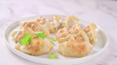 Fried dumplings . Gyoza. Healthy eating and young spring green onions. Asian food. Traditional asian Gyozas on a light background. High quality FullHD footage