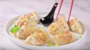 Fried dumplings with sauce . Gyoza. Healthy eating and young spring green onions. Asian food. Traditional asian Gyozas on a light background. High quality 4k footage