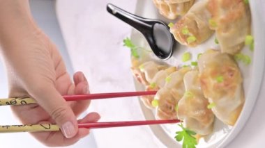 Fried dumplings with sauce . Gyoza. Healthy eating and young spring green onions. Asian food. Traditional asian Gyozas on a light background. High quality 4k footage. Vertical video