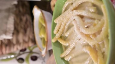 Italian Passatelli. Traditional Italian pasta cooked in broth. Typical Italian cuisine of the Puglia and Umbria region. High quality . Vertical video, pasta on a fork with hot steam