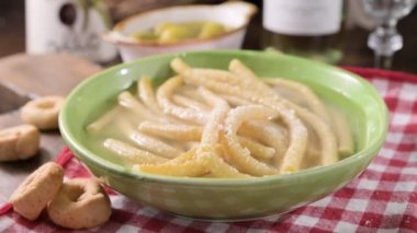 Italian Passatelli. Traditional Italian pasta cooked in broth. Typical Italian cuisine of the Puglia and Umbria region. High quality 4k footage., pasta on a fork with hot steam