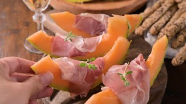 Kavunlu İtalyan jambonu. Kavunlara sarılmış geleneksel jambon dilimleri. Lezzetli aperatif. Yemek arkaplanı. Kapatın. Şarap için aperatif.