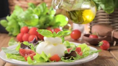 Domatesli salata, Burrata, fesleğen, zeytinyağı. Göbek adı Burratina. Puglia bölgesindeki İtalya 'nın güneyinden geleneksel peynir. Sıvı stracciatella dokusunun içinde yuvarlak yumuşak peynir 
