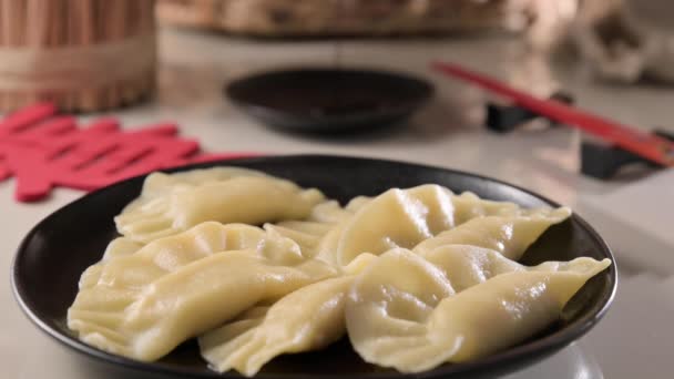 ディム 自家製中華餃子はブラックプレートで提供されています 箸で食べる 東洋料理 伝統的なランチの軽食 垂直ビデオ — ストック動画