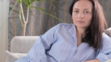 Evdeki kanepede dinlenen bir kadın. Yetişkin adam iç mekanda yakın çekim yapıyor. Uzayı kopyala Yüksek kalite 4k görüntü