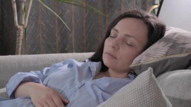 Evdeki kanepede uyuyan bir kadın. Yetişkin adam iç mekanda yakın çekim yapıyor. Uzayı kopyala Yüksek kalite 4k görüntü