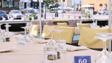 Restoran dışarıda öğle yemeği için servis edildi. Bardaklar, masa örtüleri, terasta bir masa. İtalya 'da yaz atmosferi. Yüksek kalite 4k görüntü