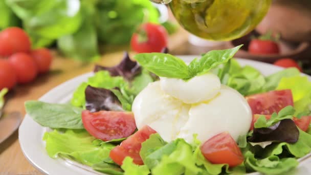トマトとサラダ ブラタ バジル オリーブオイル ミドルネームはブラティナ プーリア地方のイタリア南部の伝統的なチーズ 液体Stracciatellaテクスチャ内のラウンドソフトチーズ — ストック動画