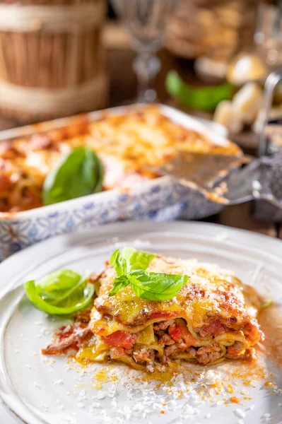 Lasagna with pesto.Italian lunch,homemade green lasagna with spinach in the dough, ragu - meat sauce, bechamel and parmesan cheese. illage dining atmosphere in Italy.