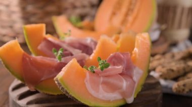 Kavunlu İtalyan jambonu. Kavunlara sarılmış geleneksel jambon dilimleri. Lezzetli aperatif. Yemek arkaplanı. Kapatın. Şarap için aperatif.