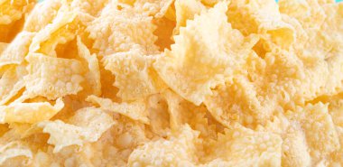 Sfrappole, chiachiere ya da melek kanatları. İtalyan Karnavalı ve tipik yemekler. Geleneksel tatlı, çıtır çıtır, bol yağda kızartılmış ve serpilmiş. Uzayı kopyala, Banner 