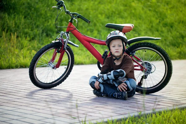 Menino feliz pedalando no parque à tarde — Fotografia de Stock