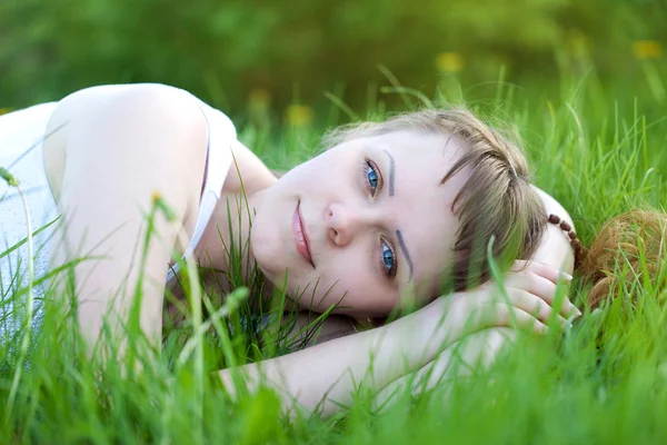 Mooie vrouw liggend op groen gras zomer — Stockfoto