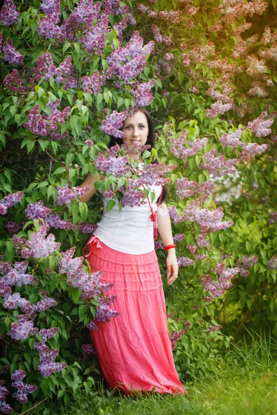 Çiçek açan lilac yakınlarında güzel bir genç kadın — Stok fotoğraf