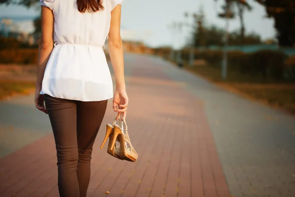 Foto van jonge vrouw hand met schoenen in het park. — Stockfoto