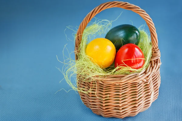 Ovos de Páscoa Pintados com cores vermelhas, amarelas e verdes no Bas — Fotografia de Stock