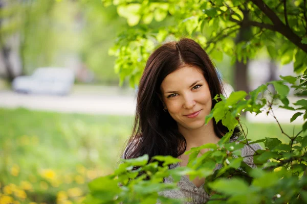 Portret mooie jonge vrouw in een tuin. — Stockfoto