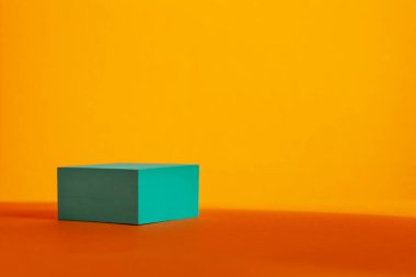 Turkuaz podyum, turuncu arka planda gölgeler var. Ürün, promosyon, satış ve afiş için sahne gösterisi.