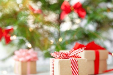 Noel ağacının altında kırmızı kurdeleli Noel hediyesi kutusu. Tatil tebrik kartı. Mutlu yıllar..