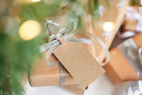 ホリデーギフトボックス 部屋の床にモミの木の下にアドレスカードタグが付いているクリスマスプレゼント クリスマスと新年のコンセプト — ストック写真