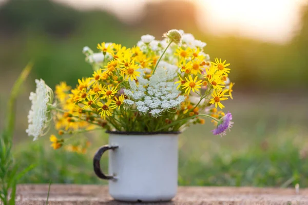 晴れた日には木製のテーブルと自然の背景に白いカップの美しい野生の花 夏のコンセプト — ストック写真