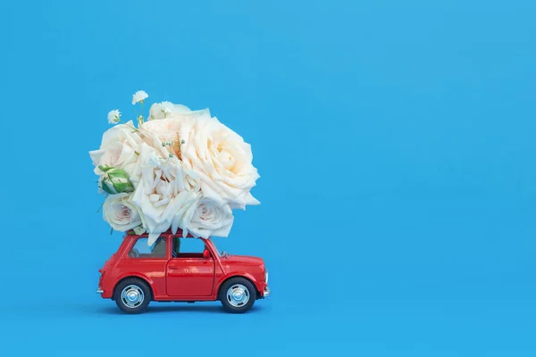 Pequeno Carro Brinquedo Vermelho Com Flores Rosas Bouquet Telhado Contra Fotografia De Stock