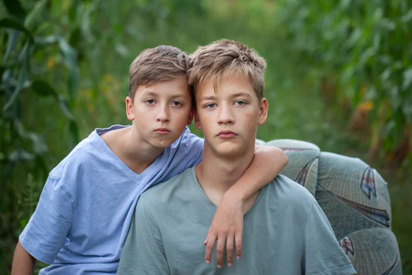 Portret Van Twee Serieuze Broers Zittend Een Fauteuil Een Veld — Stockfoto