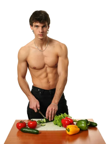 Mladý svalnatý muž připravuje salát — Stock fotografie