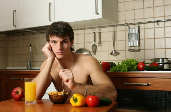 Молодой мускулистый человек ест свой завтрак — стоковое фото