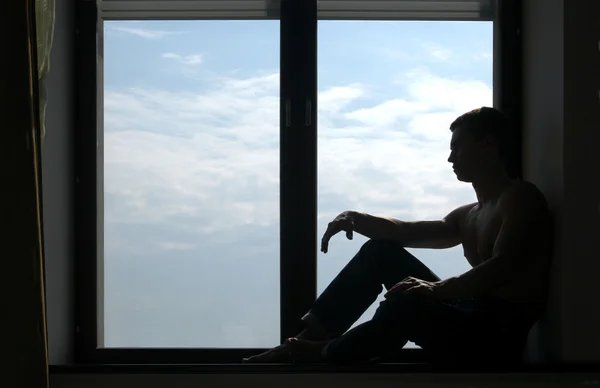 Hombre silueta en el alféizar de la ventana —  Fotos de Stock