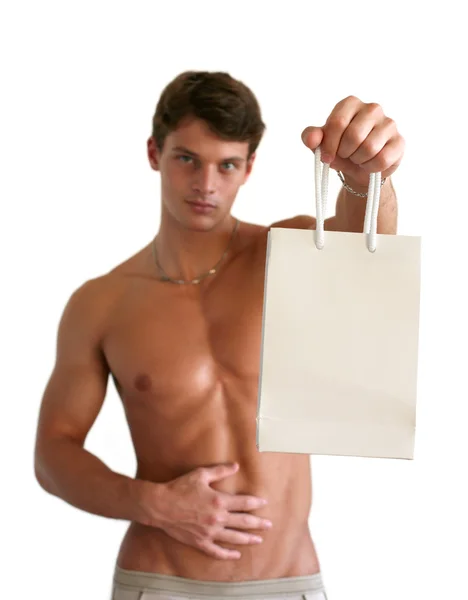 Homem muscular segurando saco de compras — Fotografia de Stock