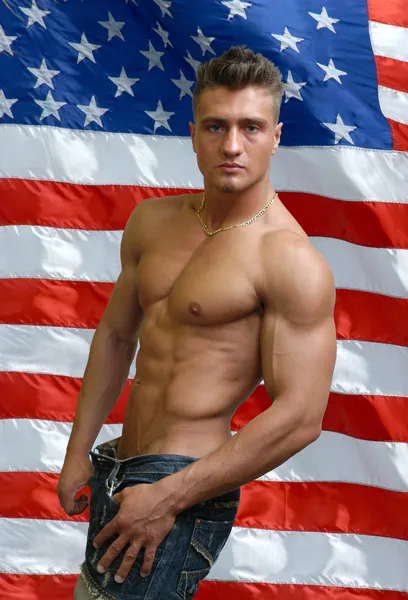 Homem sexy muscular com bandeira dos EUA por trás — Fotografia de Stock