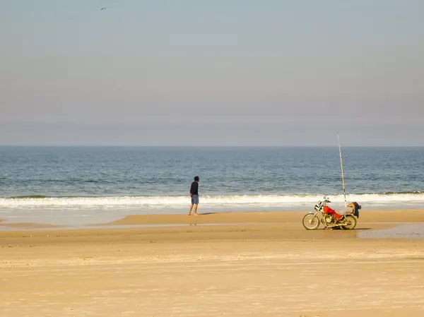 Hombre pescando en una playa solitaria —  Fotos de Stock