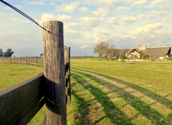 Une clôture et une maison à la campagne — Photo