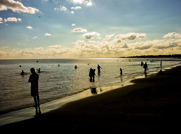 Tramonto con la gente sulla spiaggia — Foto Stock