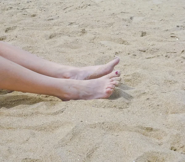Женские ноги в песке — стоковое фото