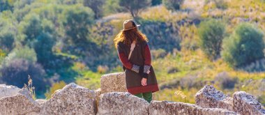 Arkaya bakan kadın ünlü arkeolojik micenas şehrinin tepesinde duruyor.