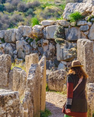 Arkaya bakan kadın ünlü arkeolojik micenas şehrinde yürüyor, Yunan
