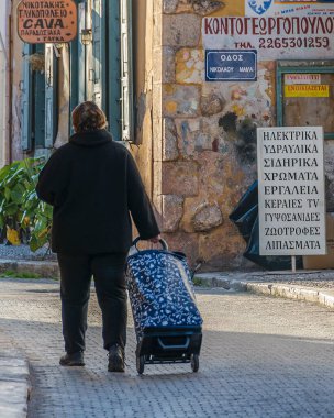 GALAXIDI, GREECE, JANUARY - 2020 - Galaksi Caddesi, Phocis, Yunanistan 'da çanta taşıyan yaşlı kadın