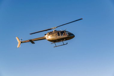 Temiz mavi gökyüzü arkaplanı üzerinde uçan helikopter