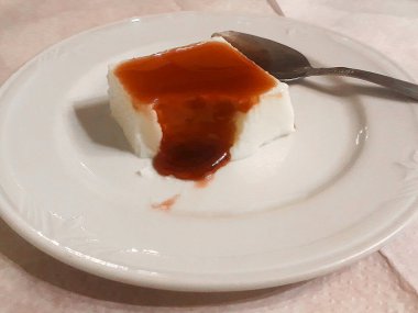 White flan with mermelad on white dish