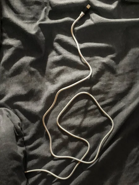 Κορυφαία Εικόνα Shot Καλώδιο Smartphone Πάνω Από Αφύλακτο Κρεβάτι Κουβέρτα — Φωτογραφία Αρχείου
