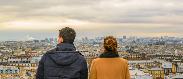 Back view couple watching the view at montmartre viewpoint, paris, france