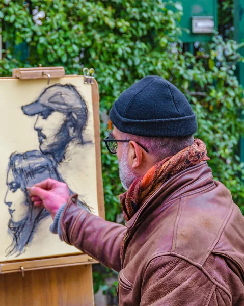 PARIS, FRANCE, JANUARY - 2020 - Old man painter drawing portraits at montmartre street.